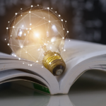 Symboliczna grafika przedstawiająca połączenie tradycyjnej nauki z nowoczesną technologią: otwarta książka, na której spoczywa świecąca żarówka opleciona cyfrową siecią białych linii i punktów. W tle widać ciemną tablicę szkolną z rozmytymi wzorami matematycznymi