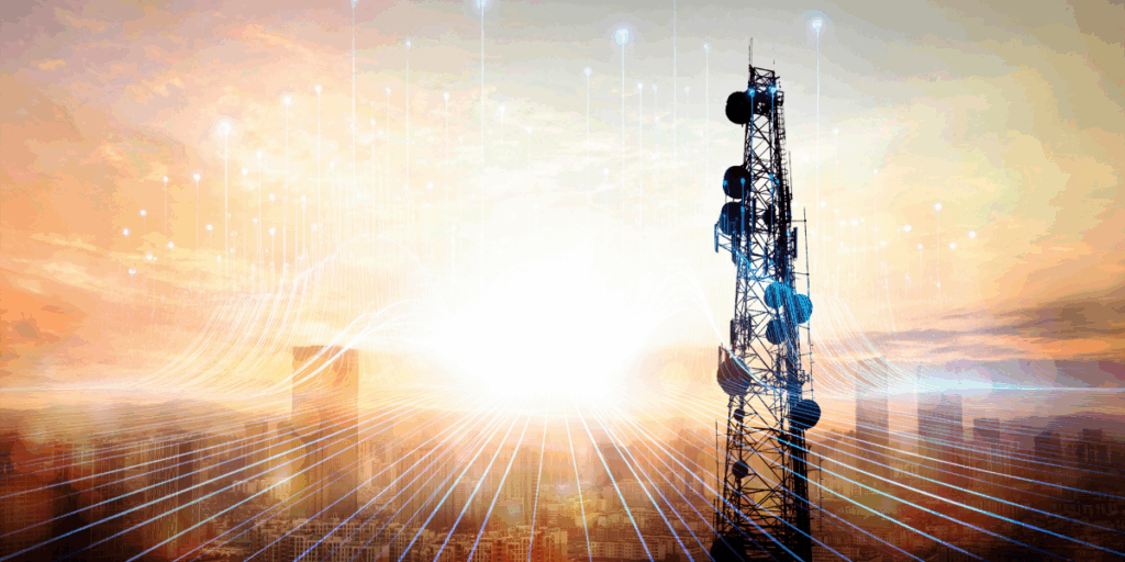 maszt telekomunikacyjny na tle wschodzącego słońca i rozmytych sylwetek miejskich budynków; na pierwszym planie dodane linie symbolizujące przepływ informacji