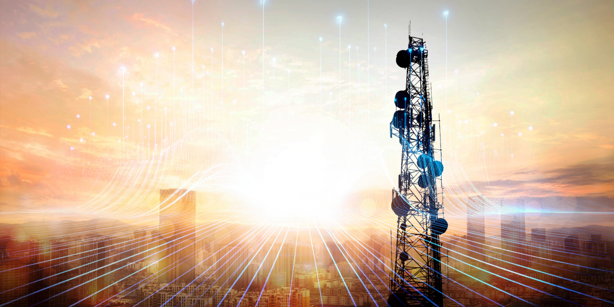 maszt telekomunikacyjny na tle wschodzącego słońca i rozmytych sylwetek miejskich budynków; na pierwszym planie dodane linie symbolizujące przepływ informacji