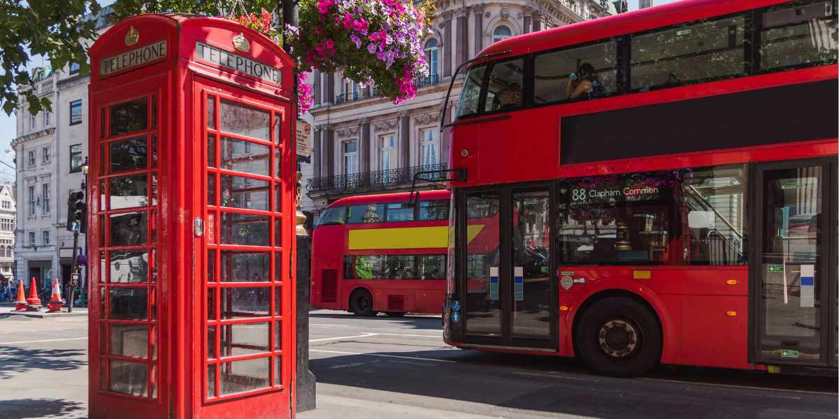 widok na ulicę Londynu z symbolami tego miasta: budką telefoniczną i piętrowym autobusem