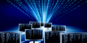 monitory komputerowe, zza których w górę "wystrzeliwuje" snop liczb