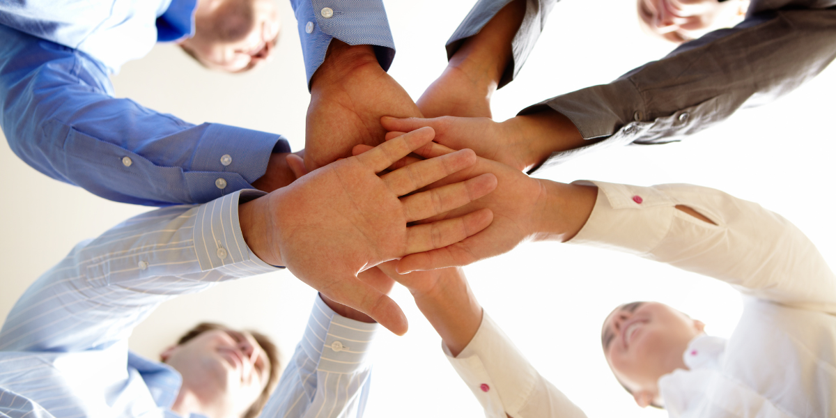 ludzie łączący dłonie w geście teamworkingu